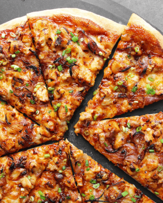 Delicious Home Made BBQ Chicken Pizza sliced and topped with green onions, ready to enjoy.