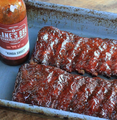 The Ultimate Low & Slow Pork Ribs Recipe featuring glazed ribs and BBQ sauce.
