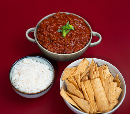 Delicious bowl of Lane's Hearty Classic Chilli Recipe Base with rice and crispy tortilla chips.